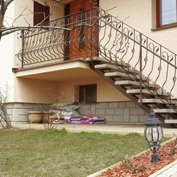 Vonkajšie kované schodisko so zábradlím pri rodinnom dome Vonkajšie kované schodisko so zábradlím pri rodinnom dome